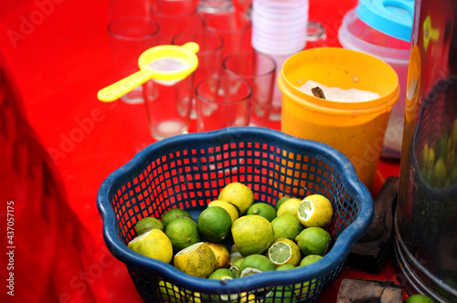 lemons,glasses,salt,filter and squeeger on moble cart of Indian street vendor selling lemonade ,on road photo