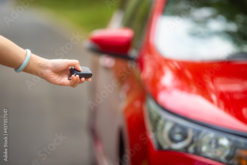 Car Auto Alarm and Remote Central Lock Car Keys in Driver Hand Sending Signal to the Vehicle