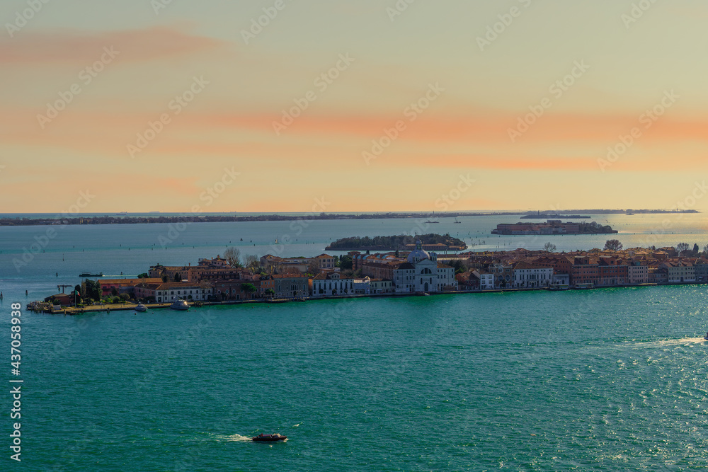 Pink sunset clouds above traditional low-rise buildings on the Venetian lagoon in Italy
