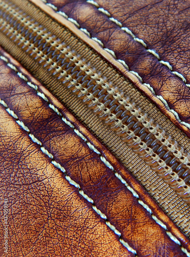 Close-up view of stiches and zipper of woman purse