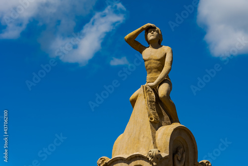Regensburg, Germany - 2021 06 02: Famous statue figure Bruckmandl on the Stone Bridge over the danube river in Regensburg in sunlight on day with clear blue sky and clouds photo