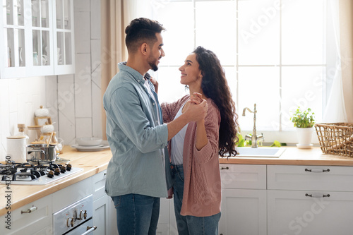 Portrait Of Happy Affectionate Arab Spouses Bonding Together In Kitchen