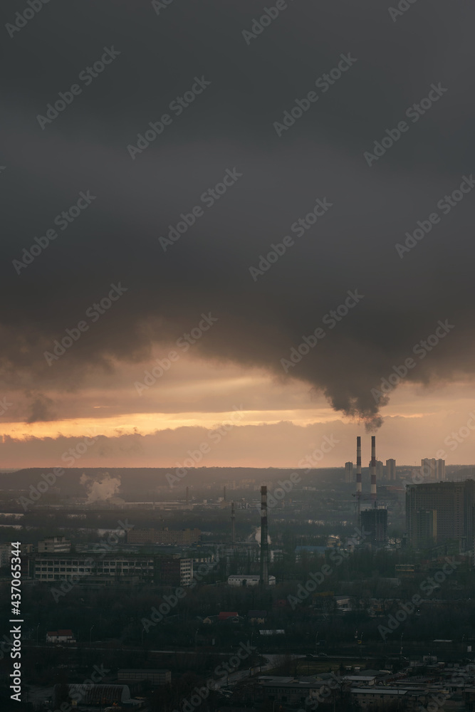 Ecology factory chimney in the Kyiv Ukraine. Pollution of air, orange sky before sunset.