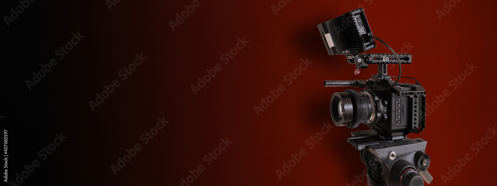 Fototapeta premium digital film camera on red background. Television or movie production banner with copy space for website design