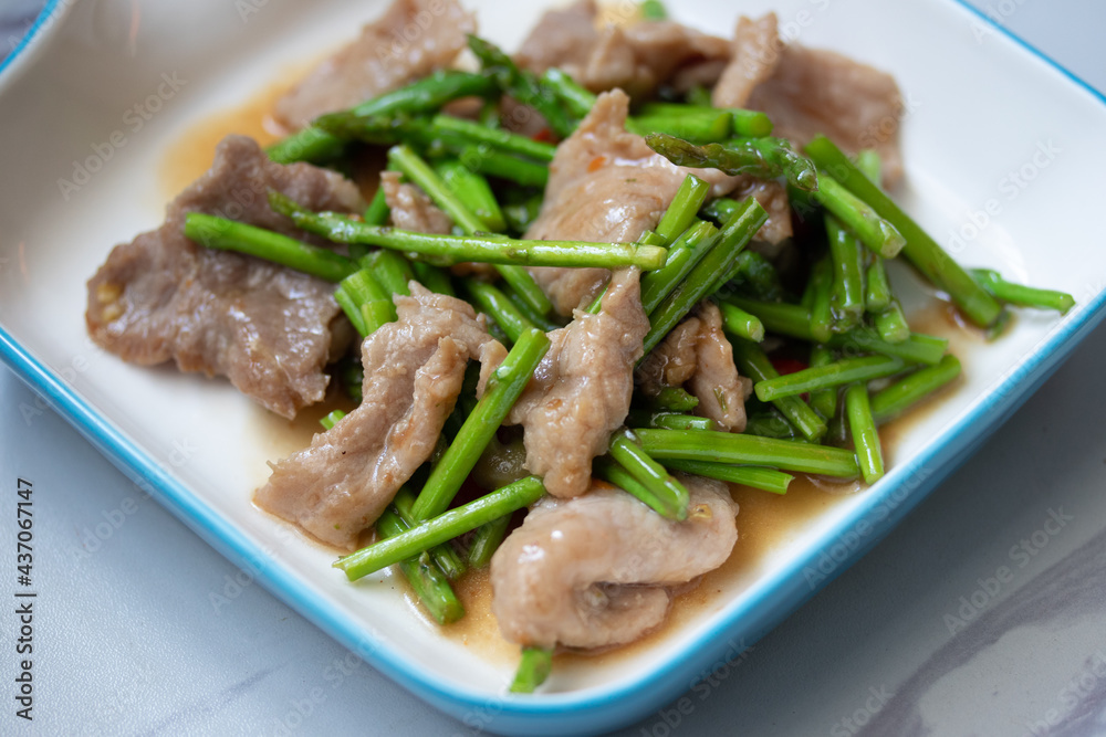 Asparagus sauteed with pork in a white ceramic dish Asparagus sauteed with pork in a white ceramic dish