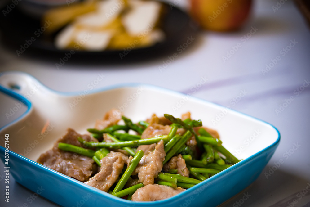 Asparagus sauteed with pork in a white ceramic dish Asparagus sauteed with pork in a white ceramic dish