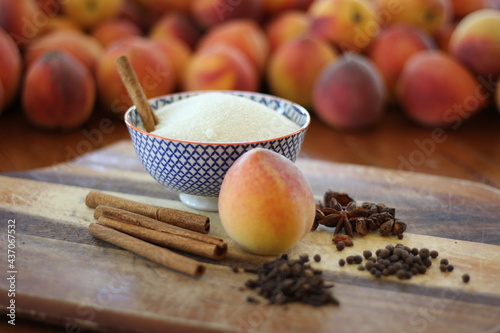 Peaches and spices on cutting board and table