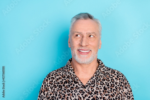 Photo of cheerful dreamy happy old man look empty space good mood isolated on blue color background
