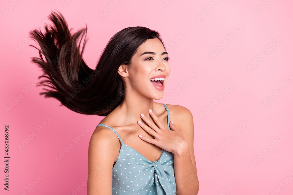 Photo of cheerful amazed young woman look empty space sock fly hair isolated on pink color background Photo of cheerful amazed young woman look empty space sock fly hair isolated on pink color background