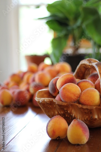 Peaches in wood basket on table