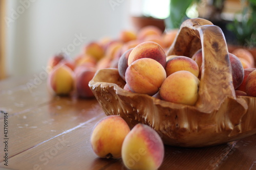 Peaches in wood basket on table