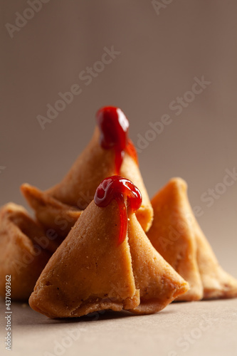 Close-up of freshly baked spicy and sweet samosa filled with dry fruits spicy dry chutney traditionally authentic Rajisthani with tomato ketchup. photo