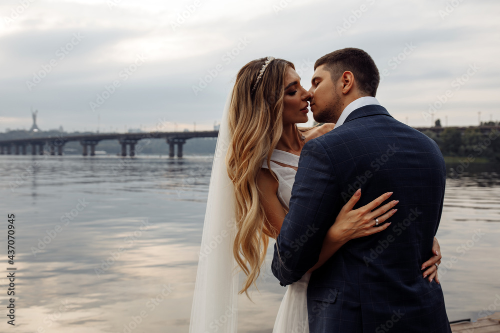 Obraz premium Walk for the newlyweds on the banks of the Dnieper. Photo session by the river. Summer evening.