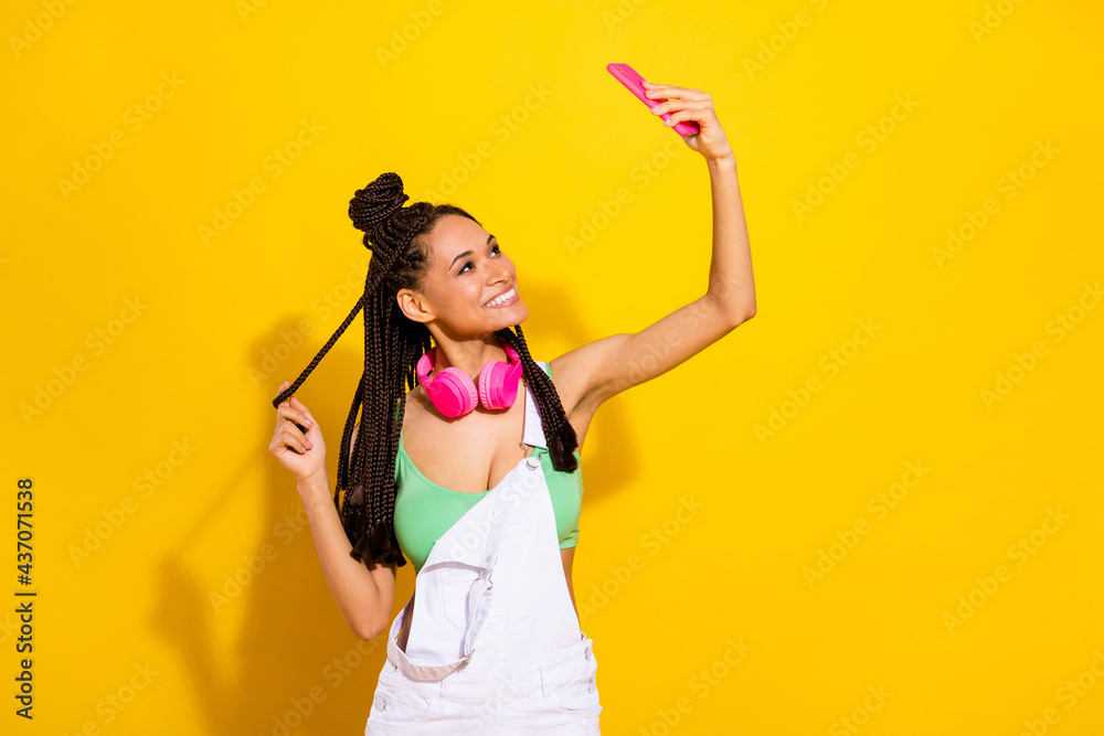 Photo of happy charming brunette dreadlocks dark skin young woman look take selfie phone isolated on yellow color background Photo of happy charming brunette dreadlocks dark skin young woman look take selfie phone isolated on yellow color background