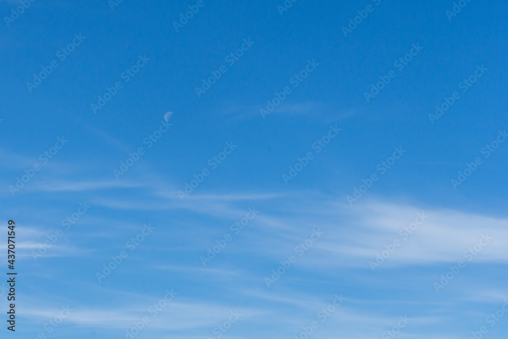 Part of the moon on the afternoon against the blue sky and white clouds Part of the moon on the afternoon against the blue sky and white clouds