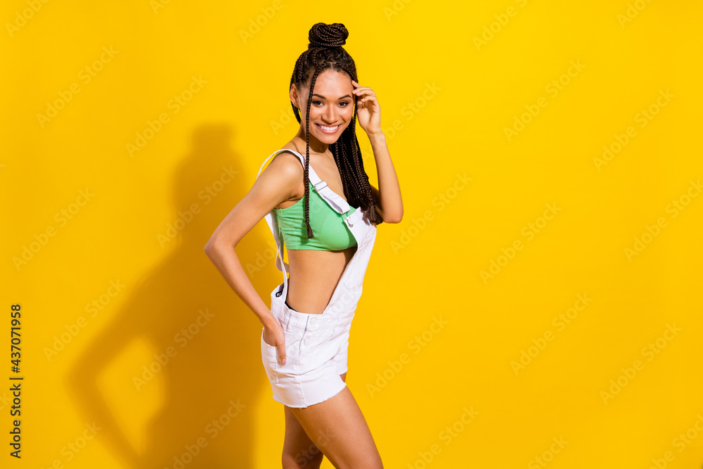 Photo of pretty adorable dark skin lady wear green crop top smiling arm pocket empty space isolated yellow color background Photo of pretty adorable dark skin lady wear green crop top smiling arm pocket empty space isolated yellow color background