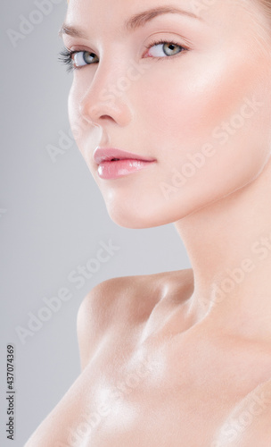 Beautiful face of young adult woman with clean fresh skin. Looking at Camera.