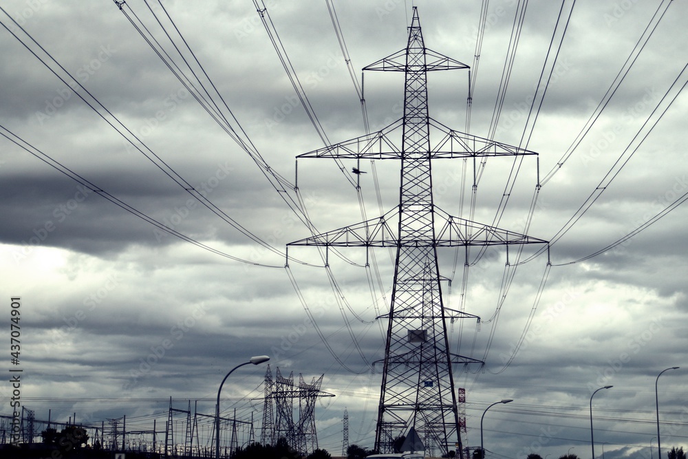 Torres de alta tensión para conducir la electricidad. Fotografía tomada un  día nublado donde destaca la silueta con el cielo oscuro. Stock Photo