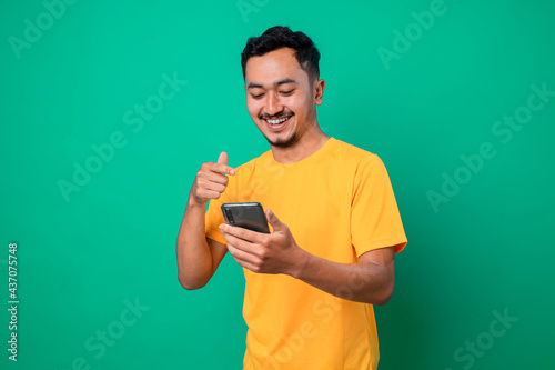 Happy teenager using smarphone with smile and surprised face expression. photo