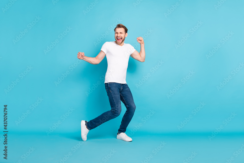 Full body portrait of cheerful excited young person raise hands fists open mouth smile isolated on blue color background