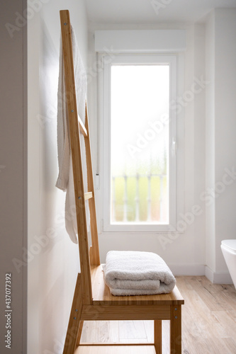 Wooden towel rack in a bright modern bathroom