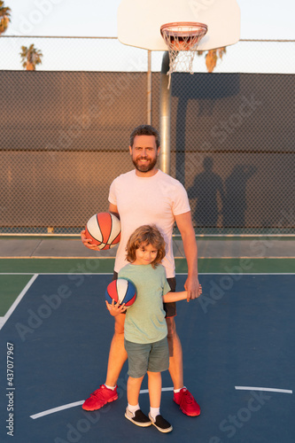 happy father and son play basketball with ball on playground, family day