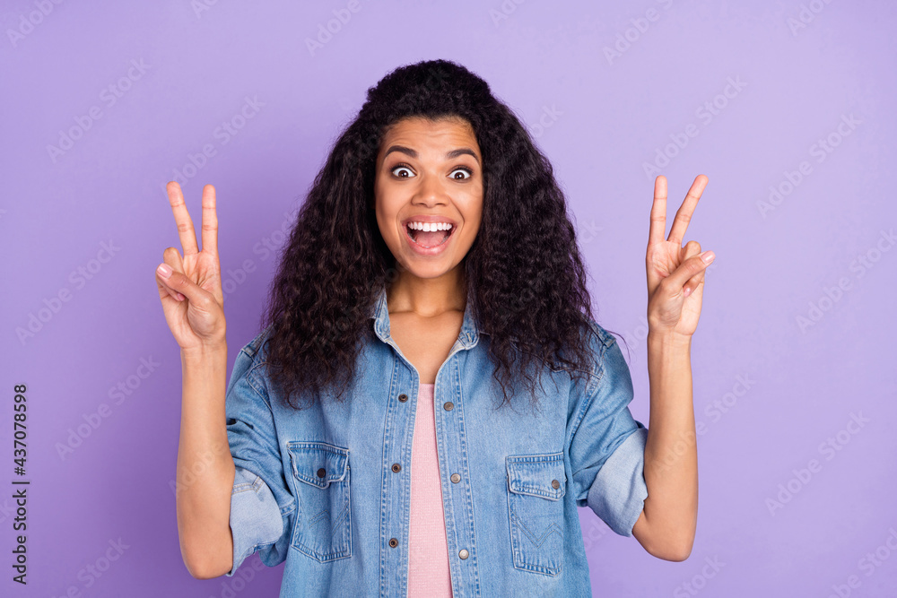 Photo of impressed funny dark skin lady wear denim shirt open mouth showing two v-signs isolated purple color background Photo of impressed funny dark skin lady wear denim shirt open mouth showing two v-signs isolated purple color background