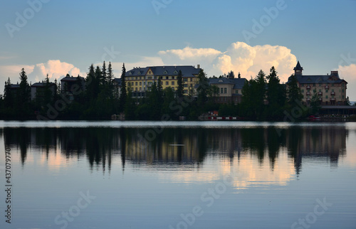 Strbske pleso, lake and small town, in the evening. Buildings and trees reflecting in the lake. High Tatras, Slovakia.