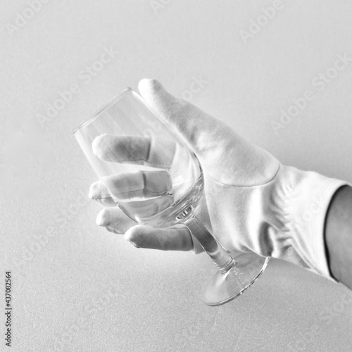 glass in hand, with white gloves, bartender