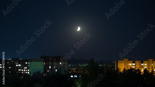 Rising moon over night city, night lights