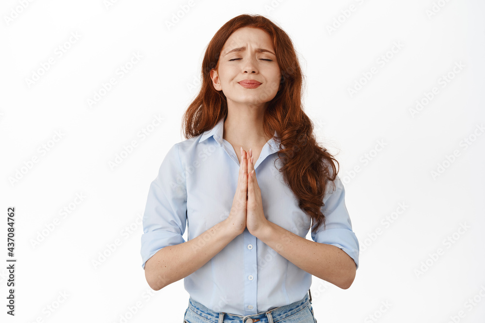 Image of redhead girl begging for help, looking pleading, need favour, supplicating say please, standing in blouse against white background Image of redhead girl begging for help, looking pleading, need favour, supplicating say please, standing in blouse against white background
