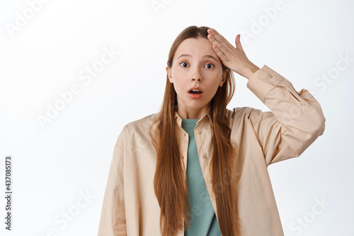 Forget remember. Troubled girl touching forehead and gasping worried, recall something, forgot to do task, standing worried against white background