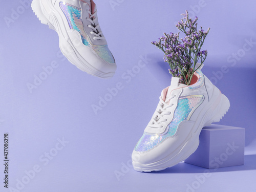 White female sneakers with sequins with flowers inside on purple background with geometric cube podium