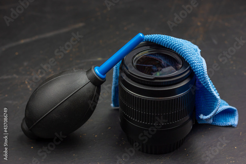Tools for cleaning photographic equipment. Photo lens on a black table.