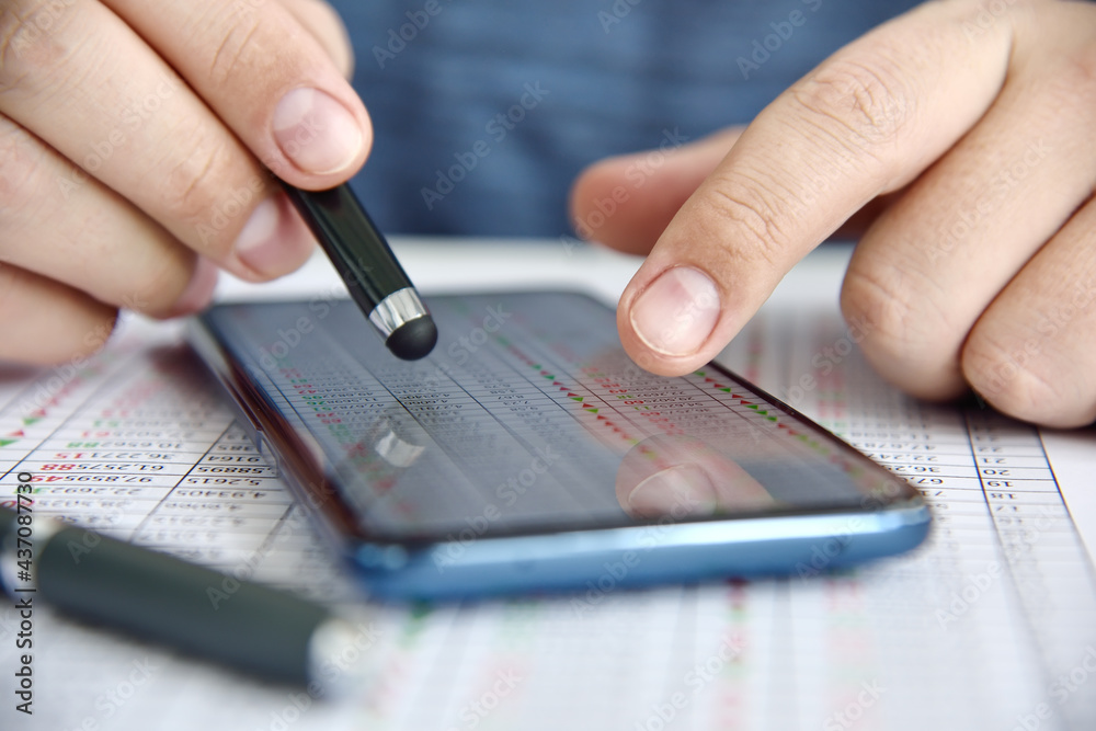 Businessman hands using smart phone with business statistic on screen. Businessman hands using smart phone with business statistic on screen.