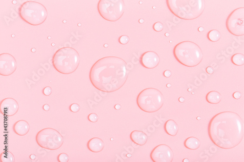 cosmetic liquid transparent gel with bubbles on pink background. Flat lay style.