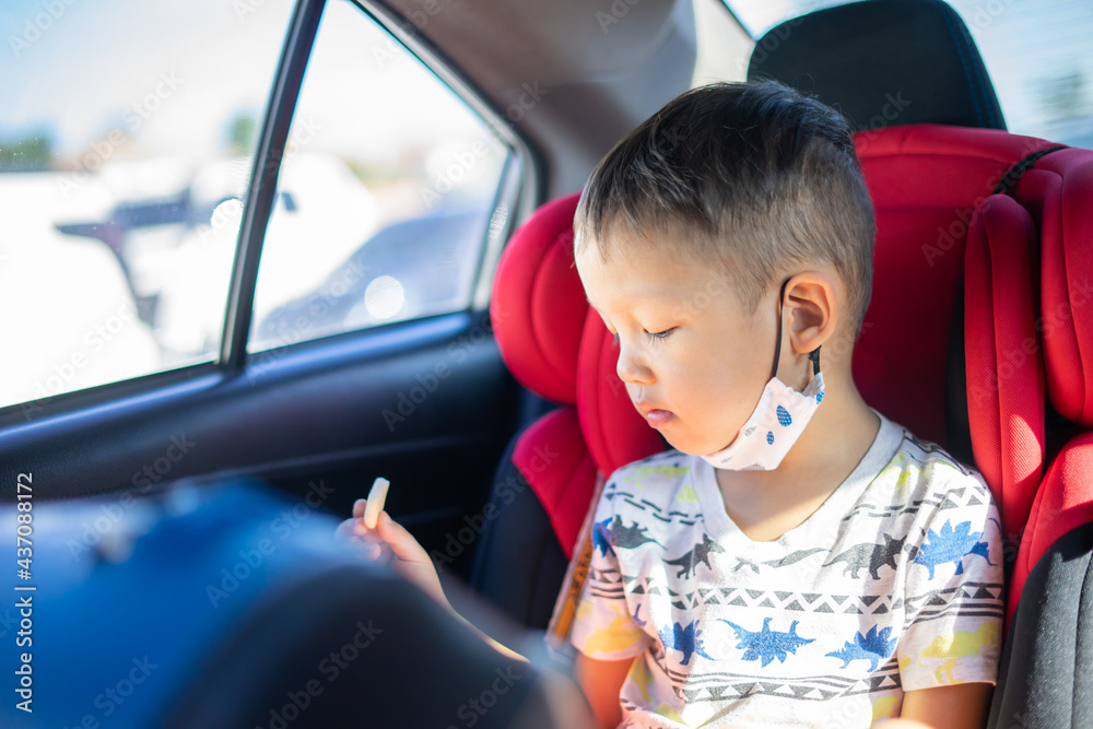 Young Asian Boy Eating a Snack in a Car Seat Young Asian Boy Eating a Snack in a Car Seat