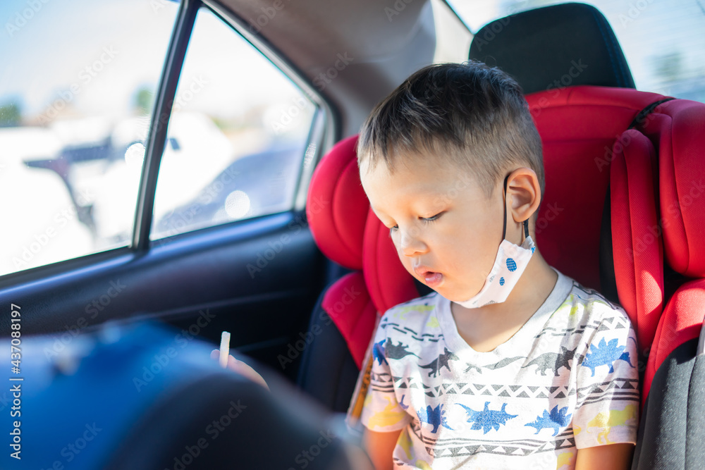 Young Asian Boy Eating a Snack in a Car Seat Young Asian Boy Eating a Snack in a Car Seat