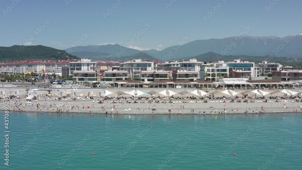 Aerial view resorts and beach. View on a wonderful beach of a resort in Sochi with crystal clear sea and people on vacation. Aerial view resorts and beach. View on a wonderful beach of a resort in Sochi with crystal clear sea and people on vacation.
