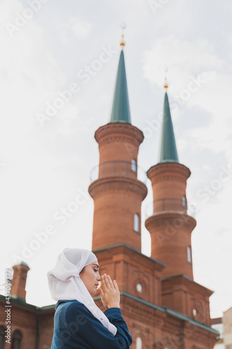 Muslim woman prayer wear hijab fasting pray to allah on mosque background