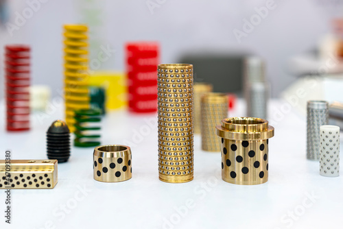 various type alloy copper or brass oilless or oil free bush with embedded solid lubricant equipment of mold or metal stamping die system for industrial on table with other instrument photo