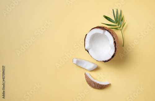 Concet of eco friendly flat lay. Fresh coconut and slices on yellow background. Healthy and vegan food. Top view and copy space