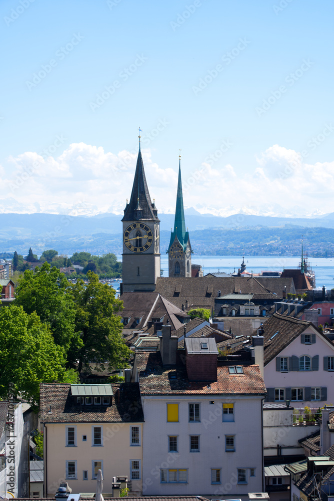 Old town of Zurich with churches St. Peter and Fraumünster (Women's Minster) with lake Zurich and Swiss alps in the background. Photo taken June 1st, 2021, Zurich, Switzerland.