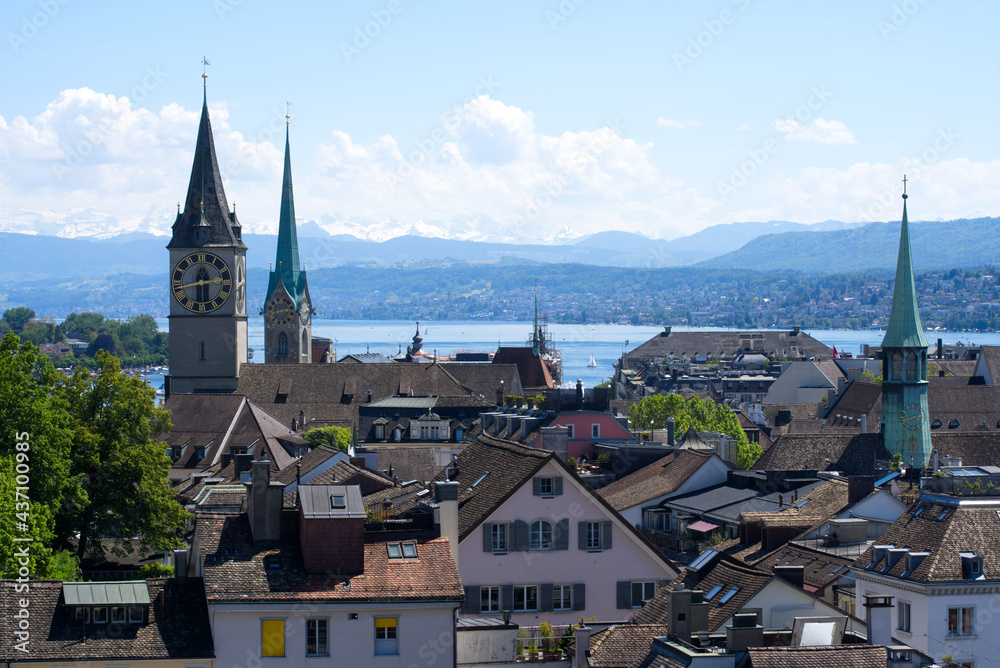 Old town of Zurich with churches St. Peter and Fraumünster (Women's Minster) with lake Zurich and Swiss alps in the background. Photo taken June 1st, 2021, Zurich, Switzerland.