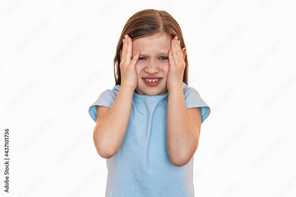 The little girl frowned and holds her hands behind his head on a white background. The child has a headache The little girl frowned and holds her hands behind his head on a white background. The child has a headache
