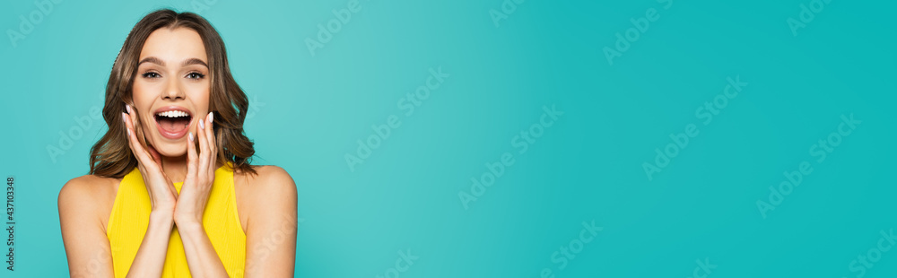 Pretty excited woman looking at camera isolated on blue, banner Pretty excited woman looking at camera isolated on blue, banner