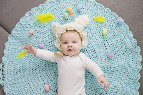 Happy adorable newborn baby in a rabbit costume. Lovely family memories, time at home, easter concept. Caucasian. Lifestyle. Horizontal. photo