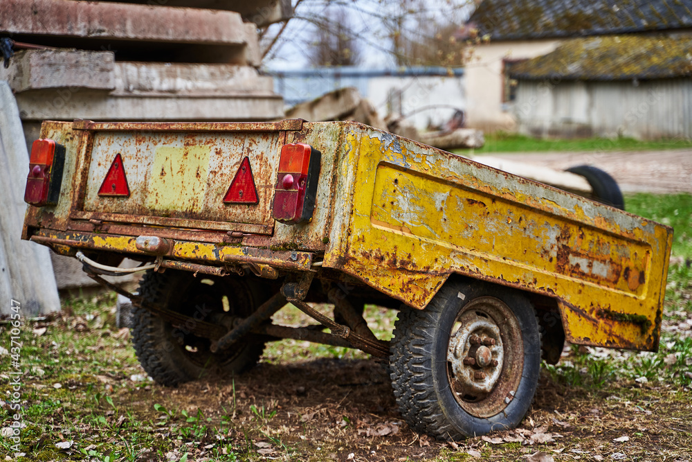 Obraz premium Old abandoned yellow rusty car trailer
