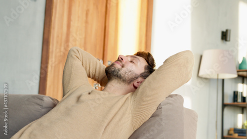 Young guy relaxes on the sofa in a calm atmosphere alone