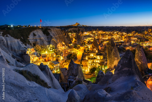 Goreme, Cappadocia, Turkey. View of the evening city from the mountain. Bright evening city and clear sky. Landscape in the summertime. UNESCO heritage. Vacation and tourism.